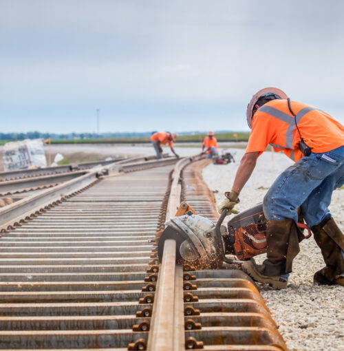 man working rail saw and railroad construction man working rail saw and railroad construction